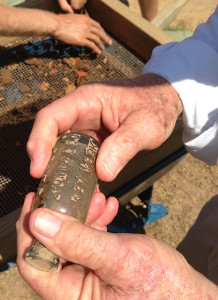 hand holding a glass bottle with stamped lettering