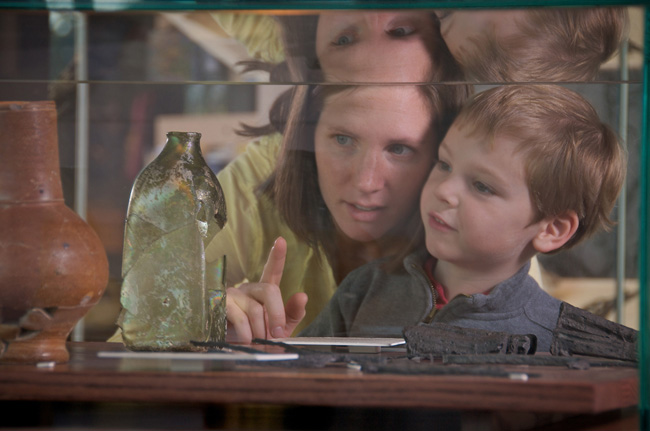 Mother and son examine artifacts in glass case
