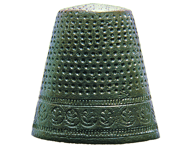 Copper alloy thimble with stamped floral decoration around base and stippling on body