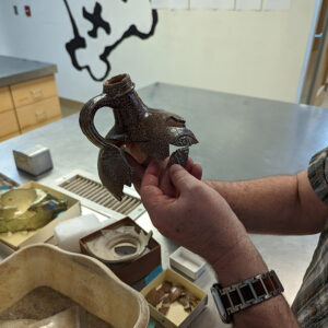 Archaeological Conservator Dr. Chris Wilkins pieces together a Bartmann Jug.
