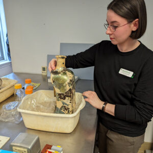 Intern Jackie Bucklew displays the glass case bottle that she's been mending over the last several months.