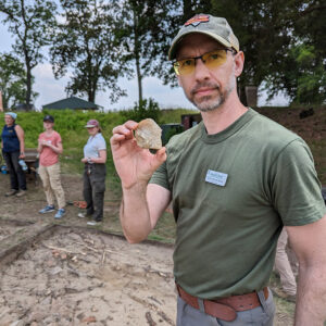 Field School Student Kurt Fredrickson holds a lithic flake found in the west "flag" excavations.