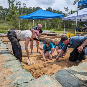 Archaeological staff and campers excavating at the borrow pit site.
