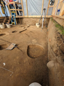 One of the postholes of the mud and stud structure. The post mold has been scored to make it easier to see.