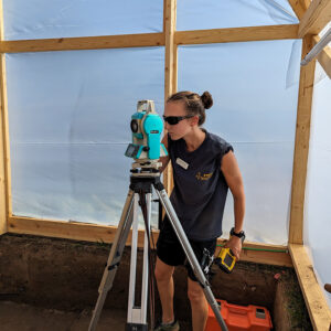 Site Supervisor Anna Shackelford records the exact location of one of the features in the burial structure. This information will be added to our digital map of archaeological features.