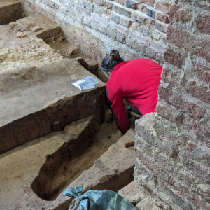 Site Supervisor Anna Shackelford takes mortar samples from the base of the foundation of the Church Tower.