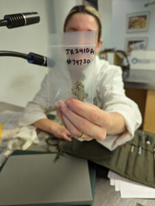 Conservation Intern Amanda Arcidiacono holds a cross-jointed section of window lead.