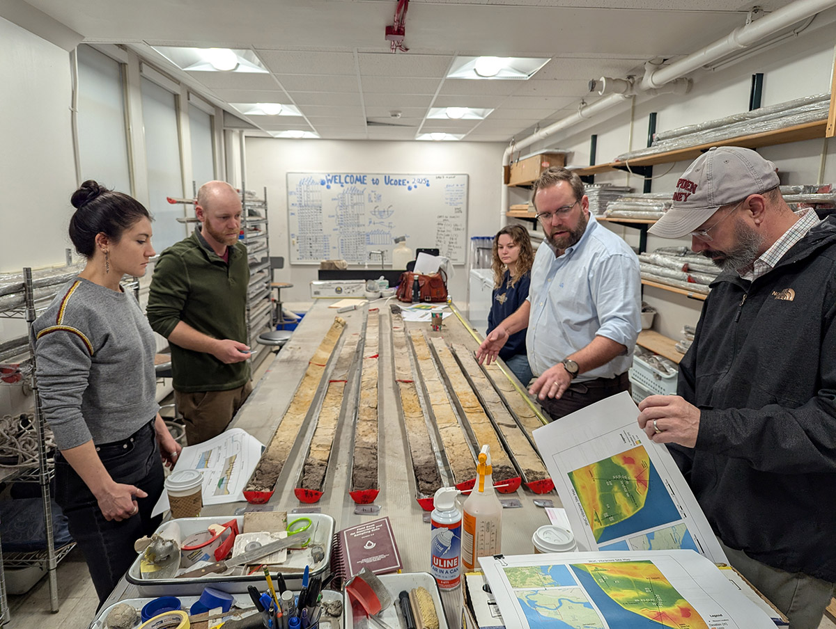 Associate Curator Emma Derry, Director of Archaeology Sean Romo, University of Connecticut's Cassie Aimetti and Dr. David Leslie, and Director of Collections and Conservation Michael Lavin examine the latest batch of vibracore samples from Jamestown.