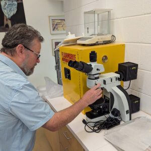 Dr. Chris Wilkins demonstrates use of the new light polarizing microscope.