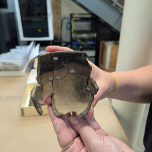 The interior of the small Roanoke Simple Stamped pot being mended by curatorial intern Molly Morgan