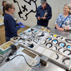 Associate Curator Janene Johnston shares horse related artifacts during an update for volunteers.