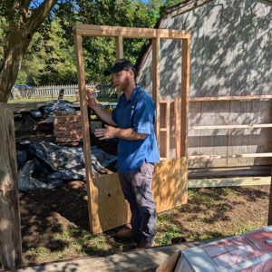 Director of Archaeology Sean Romo holds one of the modular 6' x 4' wooden sections used to build the burial structures.