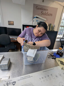 Assistant Conservator Jo Hoppe mends a London post-medieval redware jar in the lab.