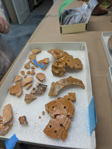 The Border ware fuming pot being mended by Assistant Curator Lauren Stephens. The new mends are being held together with painter's tape prior to using a more permanent (but reversible) adhesive.