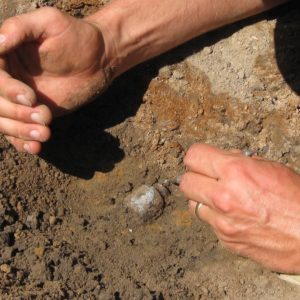 Buried glass vessel being excavated