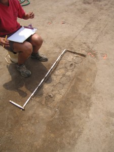 Seated student records measurements of excavated postmolds