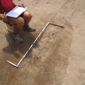 Seated student records measurements of excavated postmolds