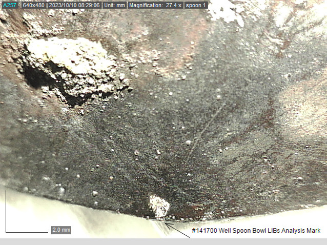 A close-up image of the bowl of the spoon. At the bottom is a very small mark where the LIBS measurement was taken 