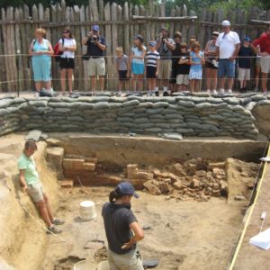 Group watches archaeologists examine cellar