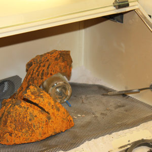 corroded close helmet in an air abrasion chamber