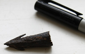 Crossbow bolt fragment next to a pen tip for scale