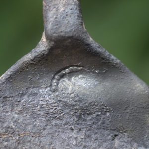 Close-up of a crescent-shaped maker's mark on the top of a spoon bowl