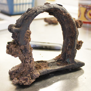 corroded semi-circular iron object