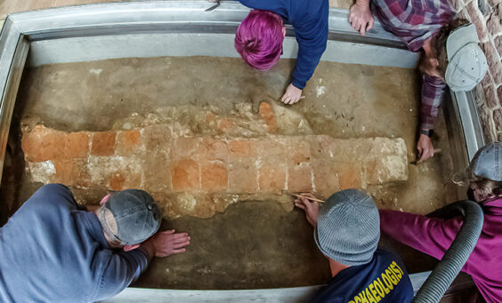 The archaeological team does the final excavations of the 1617 church foundations prior to the installation of the glass portal.