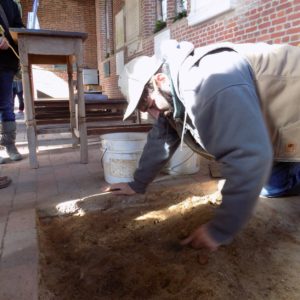 Archaeologist excavating in brick church floor