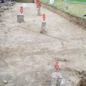 Notated concrete posts in excavation unit