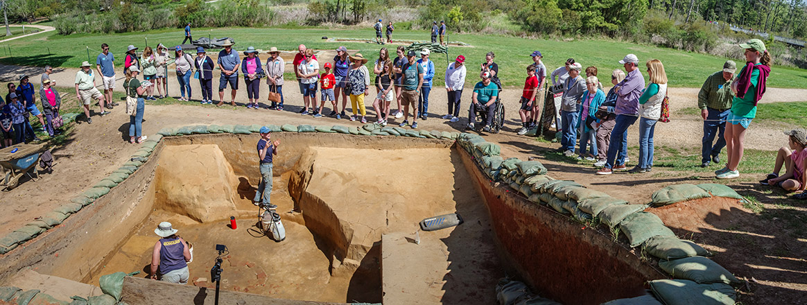 Staff Archaeologist Natalie Reid explains the excavations of the 1608 ditch and 1610s well during an archaeology tour.