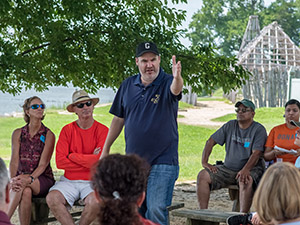 Mark Summers stands in a group of visitors who are listening to him during a history walking tour 