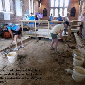 Visitors watch excavators shovel in brick church