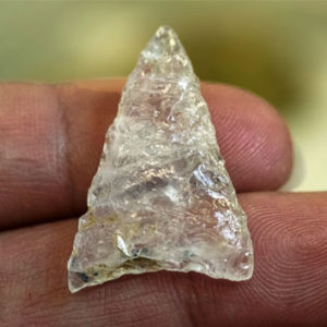 Hand holding triangular quartz crystal point