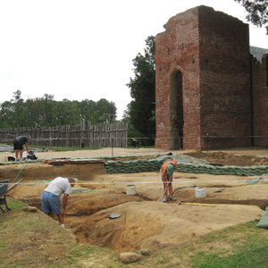 Archaeologists excavate in front of brick church
