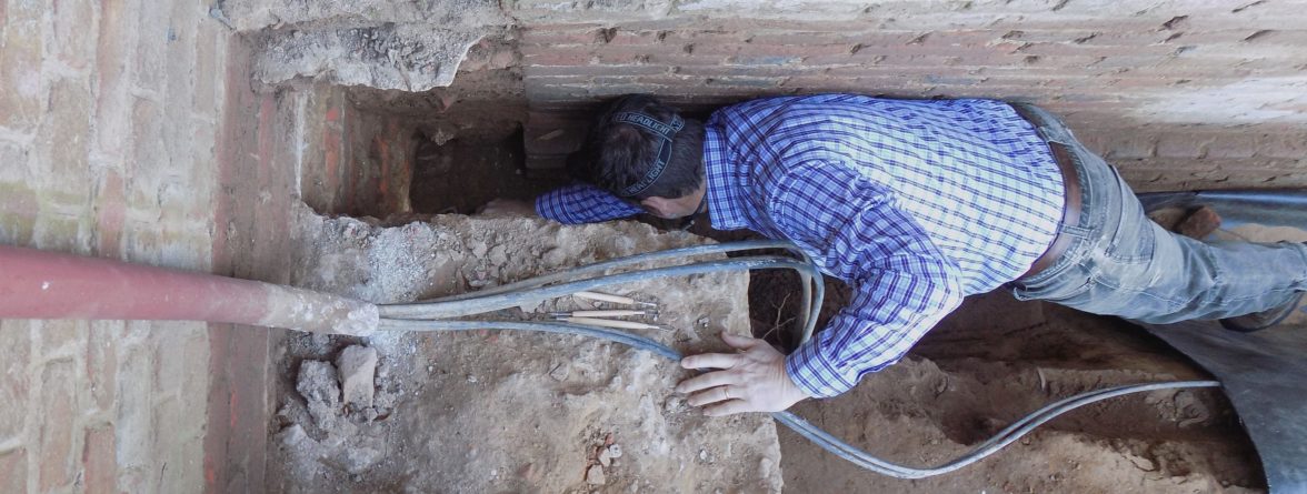 Archaeologist reaching into excavated corner