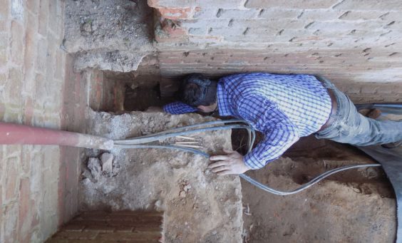 Archaeologist reaching into excavated corner
