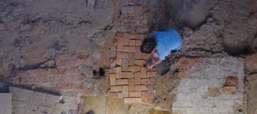 Archaeologist excavates brick floor