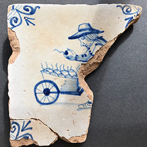 Blue and white Delft tile showing farmer with apple cart