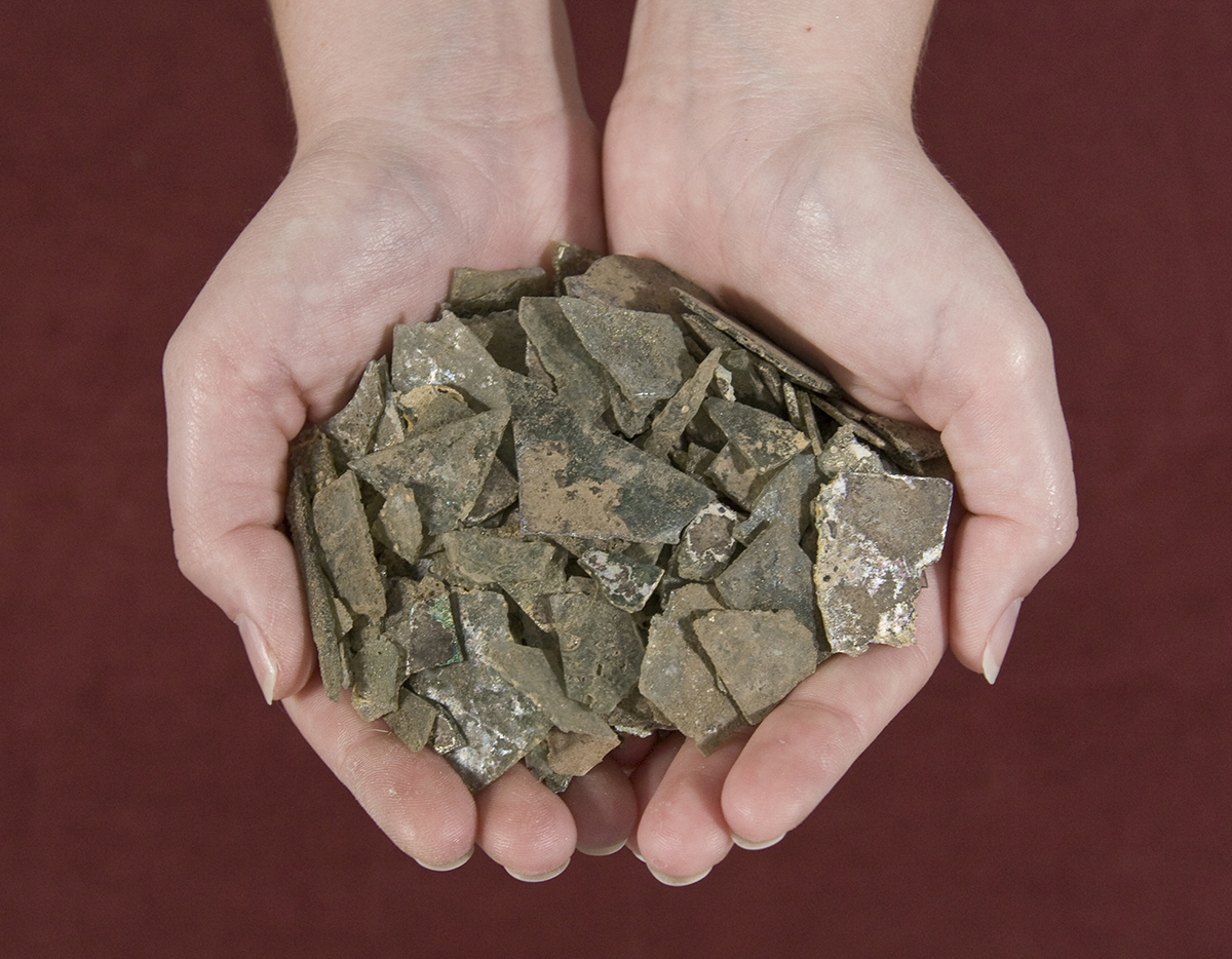 Researcher's hand holding small globular clear cupping glass