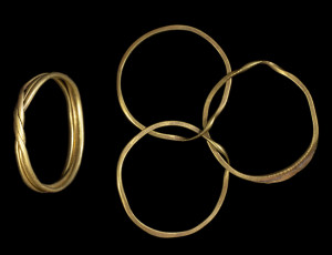 Two views of a gimmel ring, one of three connected hoops and the second of the joined ring