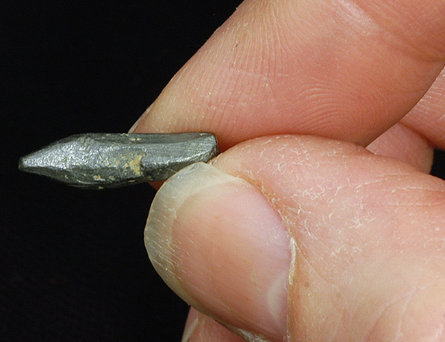 Hand holding pointed graphite piece