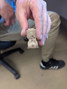 A copper alloy latch that once helped keep a book closed. This example is decorated with acorns.